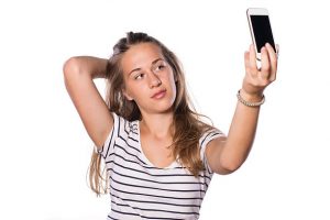 Young woman making selfie on white isolated background